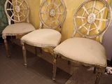 trois chaises à roulettes sont alignées contre un rideau jaune
