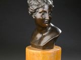 a bronze bust of a woman on a pedestal
