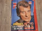 affiche posée sur le sol d'un restaurant faisant la promotion de « Johnny – Les femmes de ma vie »