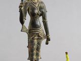 statue d'une femme tenant un oiseau à côté d'une figurine représentant une poire