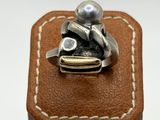 sterling silver ring with pearl on top of a brown leather box