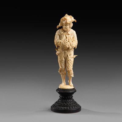 une figurine en ivoire sculpté représentant un homme tenant un panier