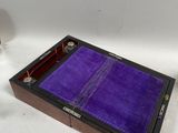 une petite boîte avec un couvercle violet et un verre de vin à côté