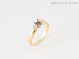 a close up of a diamond ring on a white surface