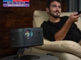 a man sitting in a chair with a projector on his lap