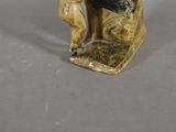 a figurine of a man sitting on a rock