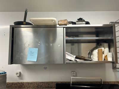 une armoire métallique sur laquelle est accrochée une pancarte, dans une cuisine
