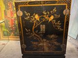 une armoire noire ornée d'un motif représentant un oiseau