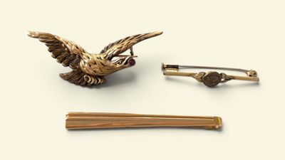 a bird brooch and a pair of chopsticks on a table