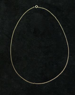 a gold chain necklace with a white pearl on a black background