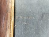 an old book with writing on it sitting on top of a wooden table