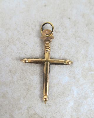 a close up of a gold cross on a white surface