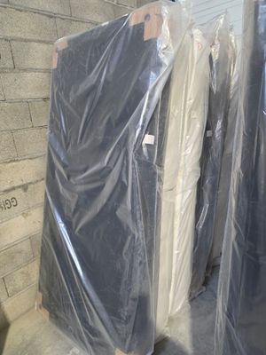 many mattresses wrapped up in plastic on the floor