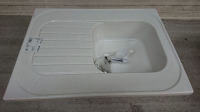 un lavabo blanc posé à même le sol
