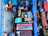 de nombreuses petites voitures dans un panier bleu posé par terre