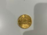a close up of a gold coin on a white surface