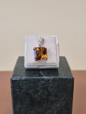 pendentif en argent sterling et citrine posé sur un bloc de marbre