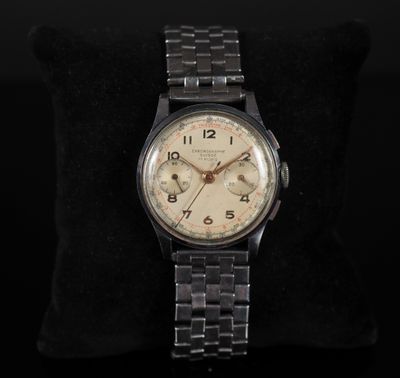 a close up of a watch sitting on a pillow on a black surface