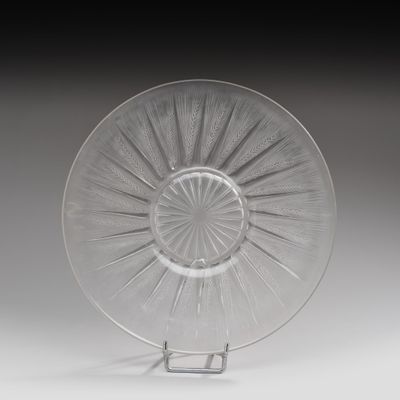une photo représentant une plaque de verre transparent posée sur un support, sur une surface blanche