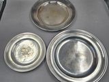 three silver plates sitting on top of each other on a stove