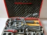 une mallette rouge contenant des outils, posée sur une table