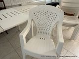 a white plastic chair sitting in front of a white table