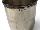 a silver cup that is sitting on a white surface