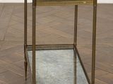 an image of a glass and brass side table on a parquet floor