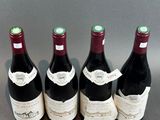 four bottles of wine are lined up on a table