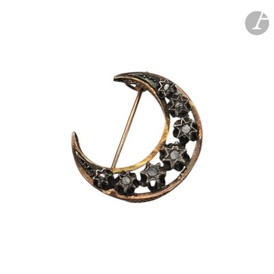 une photo d'une broche en forme de croissant sertie de diamants noirs