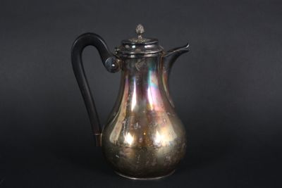 an antique silver coffee pot with a black handle on a black background