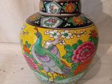 un vase jaune orné d'un oiseau sur fond blanc