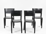 three black leather chairs sitting next to each other on a white surface
