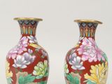 une paire de vases décorés de fleurs et de feuilles peintes sur fond blanc