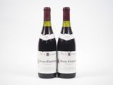 deux bouteilles de vin rouge posées l'une à côté de l'autre sur une surface blanche