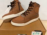 a pair of brown sneakers sitting on top of a cardboard box