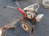a small red and white lawn mower sitting on the ground