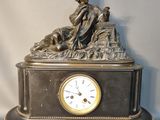 une statue de femme assise au sommet d'une horloge