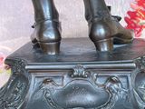 a bronze statue of a woman standing on a box