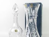 a glass bottle and a glass decanter sitting next to each other