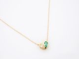 un collier en or avec un pendentif en forme de cœur vert sur fond blanc