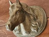 une tête de cheval accrochée au mur au-dessus d'une table en bois