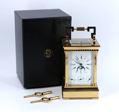 une image représentant une horloge dorée avec une boîte noire à côté