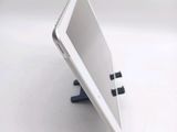 a tablet computer sitting on a stand on a white surface