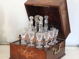 des bouteilles et des verres dans une caisse en bois posée sur une table