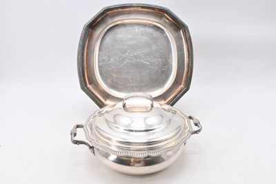 une cocotte ancienne en métal argenté avec un couvercle, posée sur un plan de travail blanc