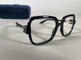 black glasses with gold rims on a white surface next to a blue case