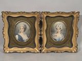 two framed portraits of a woman and a man in formal dress