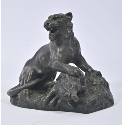 statue en bronze représentant un lion sur un rocher, sur fond blanc
