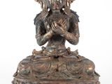 une statue antique en bronze représentant une femme assise sur un lotus